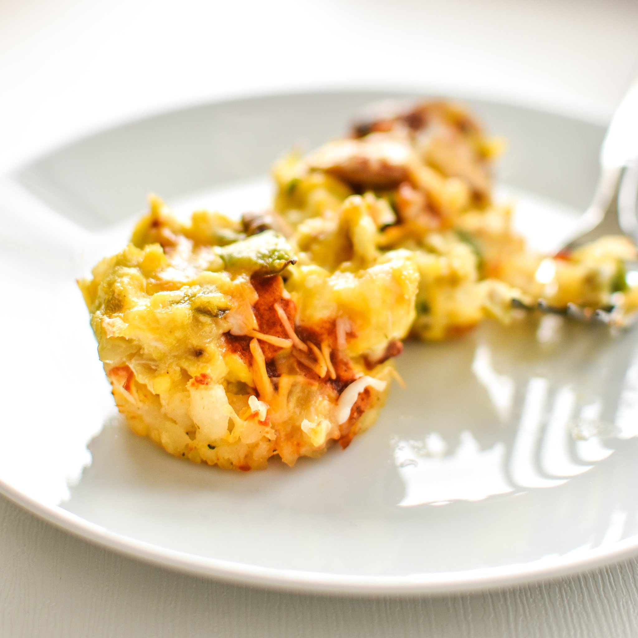 These Southwest Muffin Tin Hash Brown Egg Cups are perfect for your breakfast meal prep! Southwest hash browns with veggies, cheese, scrambled eggs, and a tiny dose of chipotle Tabasco! - ProjectMealPlan.com