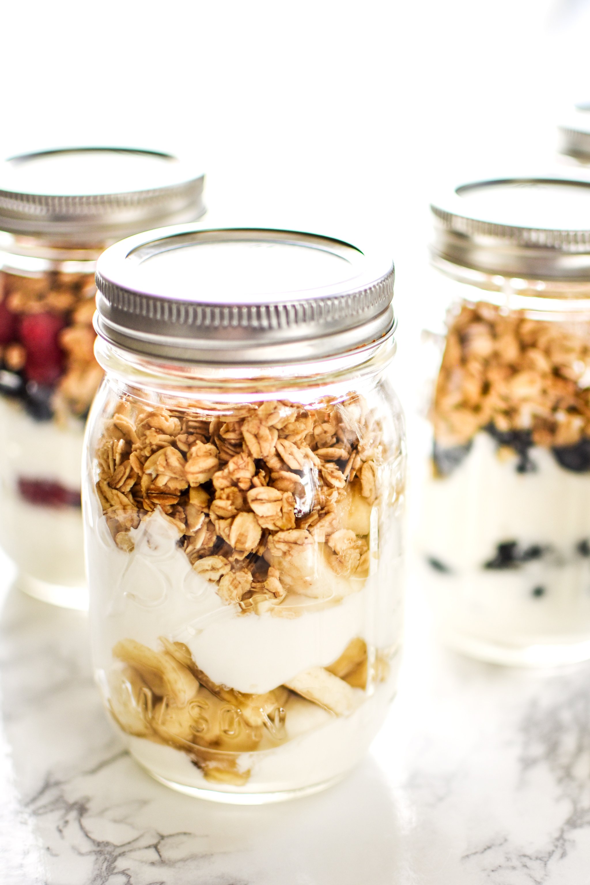 Greek yogurt, fruit and granola meal prepped into mason jar parfaits.