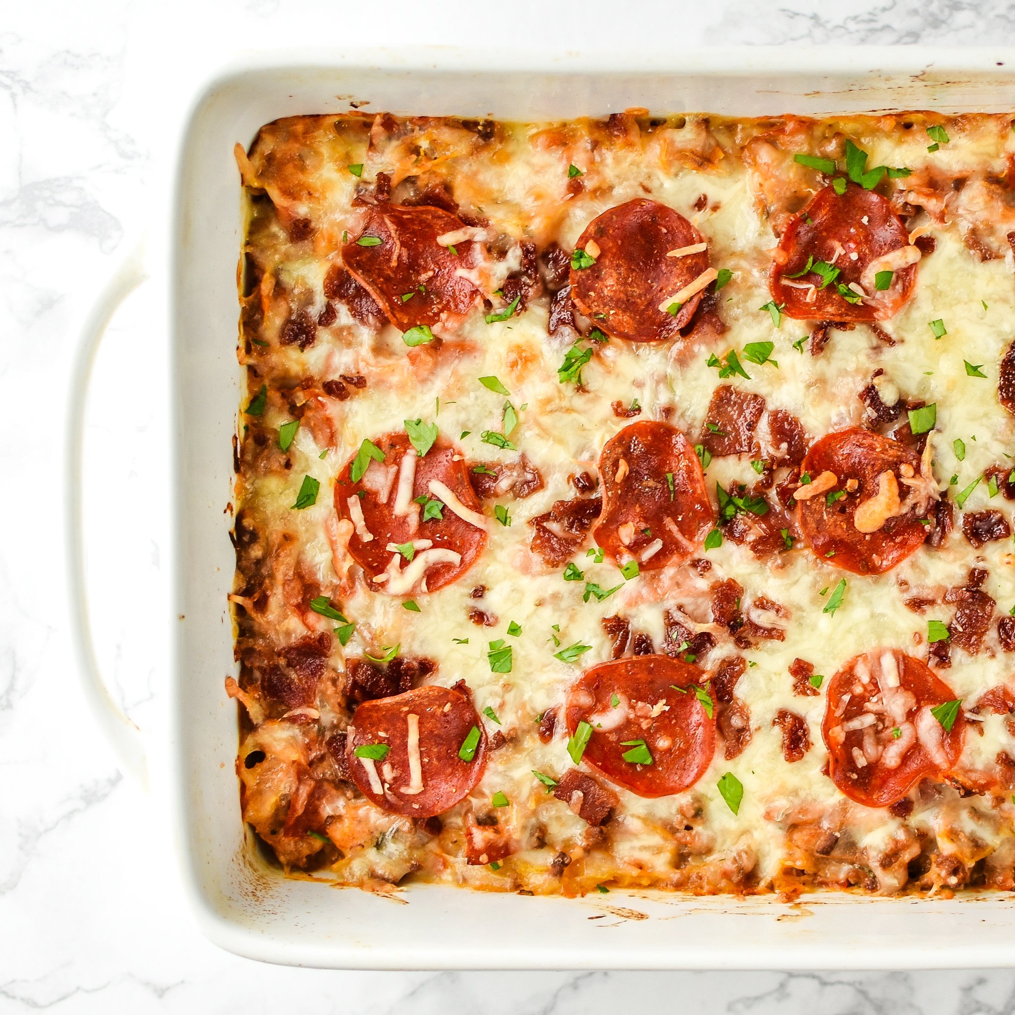 Mouth-watering top view of Meat Lover's Spaghetti Squash Pizza Casserole - It's pizza, but morphed into a not-that-bad-for-you spaghetti squash casserole with meat lover's toppings! - ProjectMealPlan.com