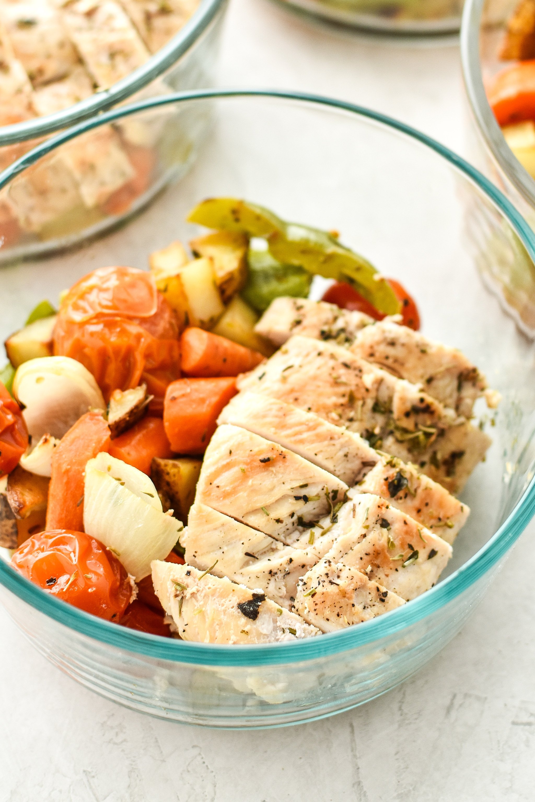 Simple, healthy, Meal Prep Italian Seasoned Chicken with Roasted Imperfect Vegetables including potatoes, cherry tomatoes, onions, and bell peppers!