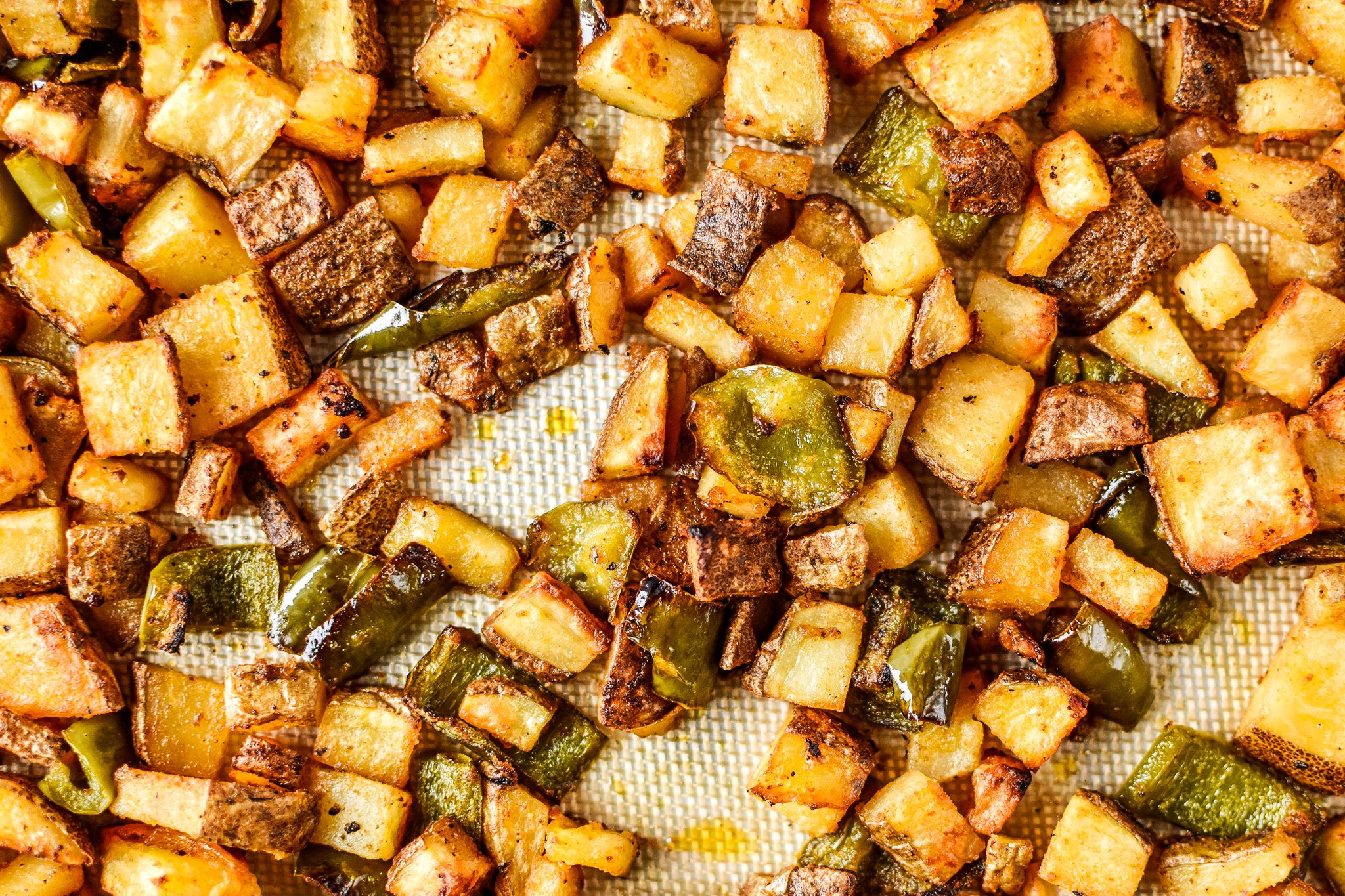 Roasted breakfast potatoes and peppers fresh out of the oven, top view.