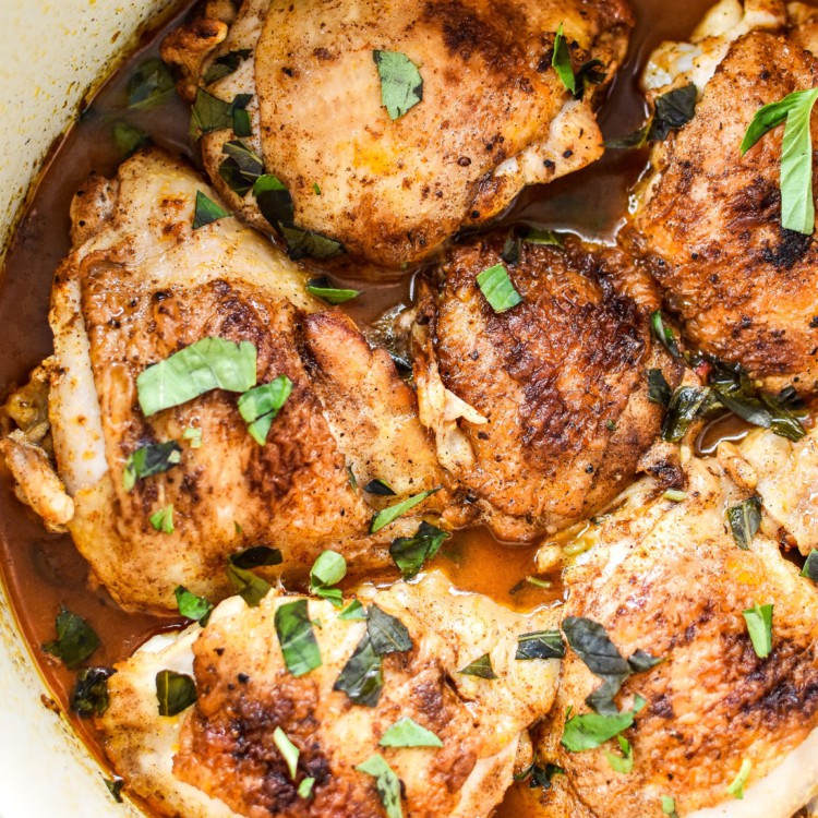 Hot Basil Coconut Braised Chicken Thighs just finished cooking and sitting in a Dutch Oven.