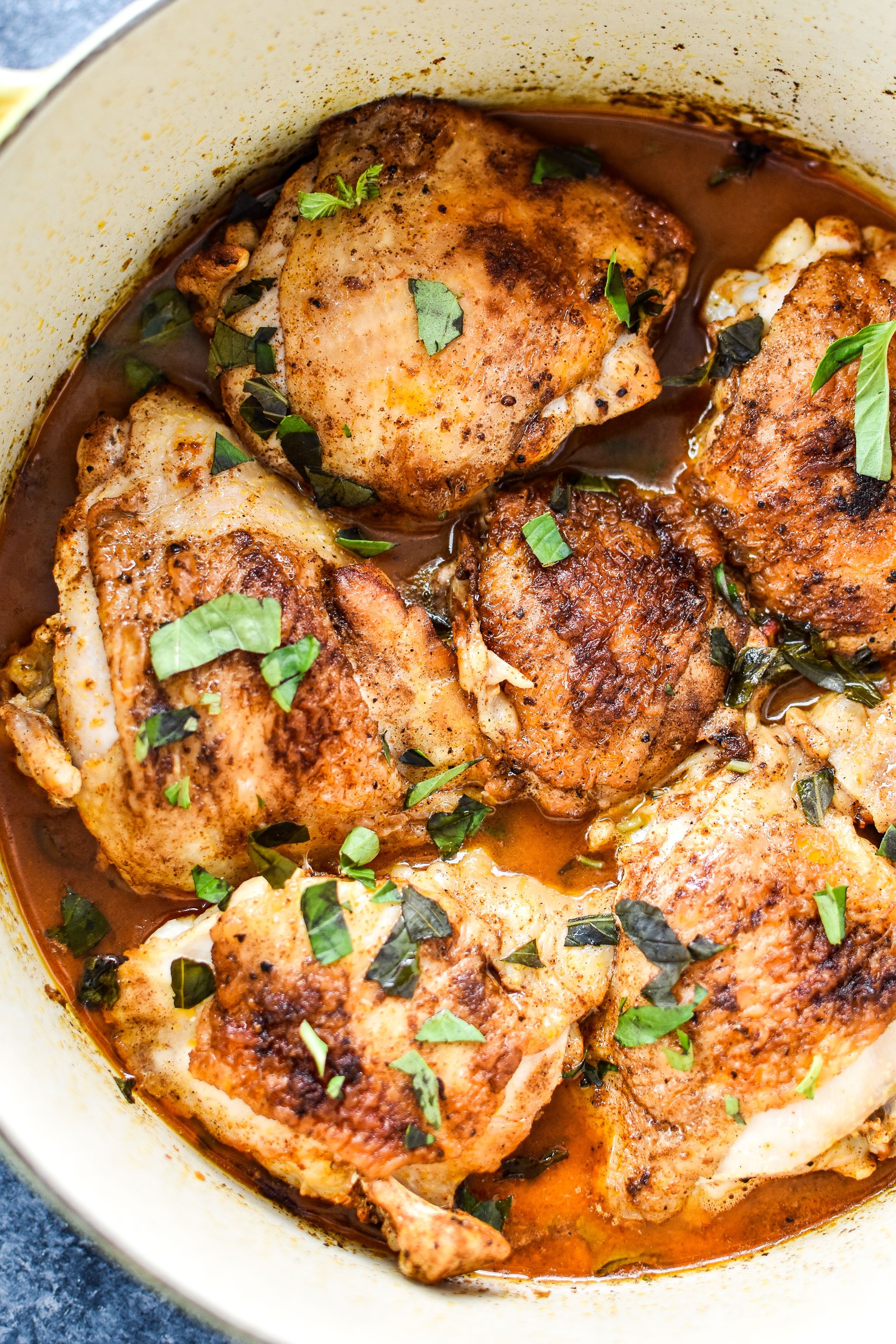 Hot Basil Coconut Braised Chicken Thighs just finished cooking and sitting in a Dutch Oven.
