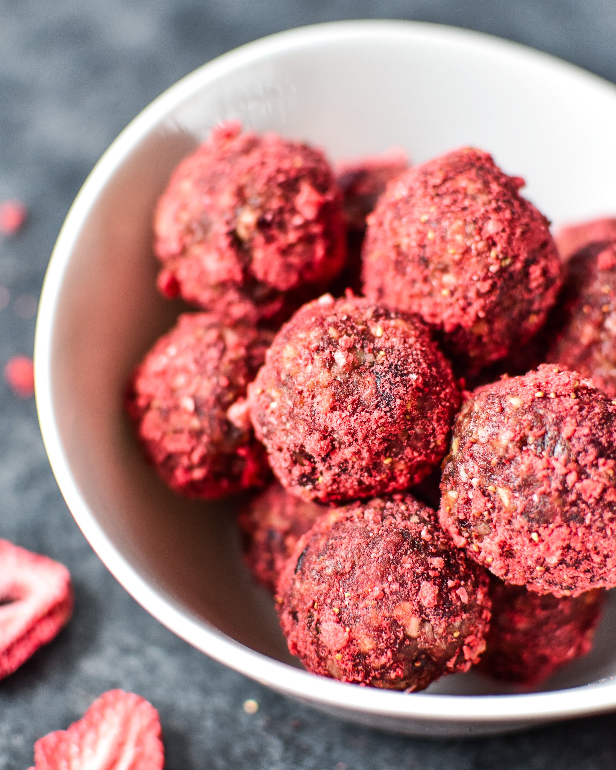 A white bowl full of Spiced Berry Bliss Balls.