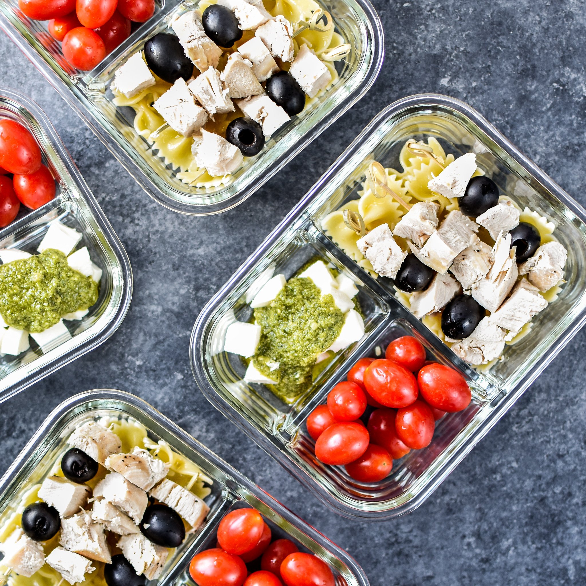 A view of the DIY Chicken Pesto Pasta Skewers Meal Prep from above, including grape tomatoes, fresh mozzarella and traditional pesto!