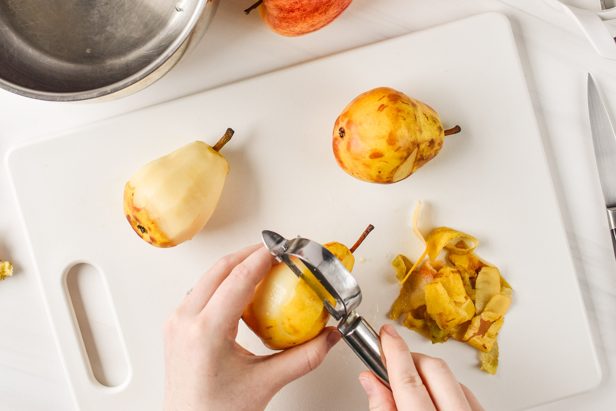 Peeling pears for Ginger Pear Cinnamon Applesauce