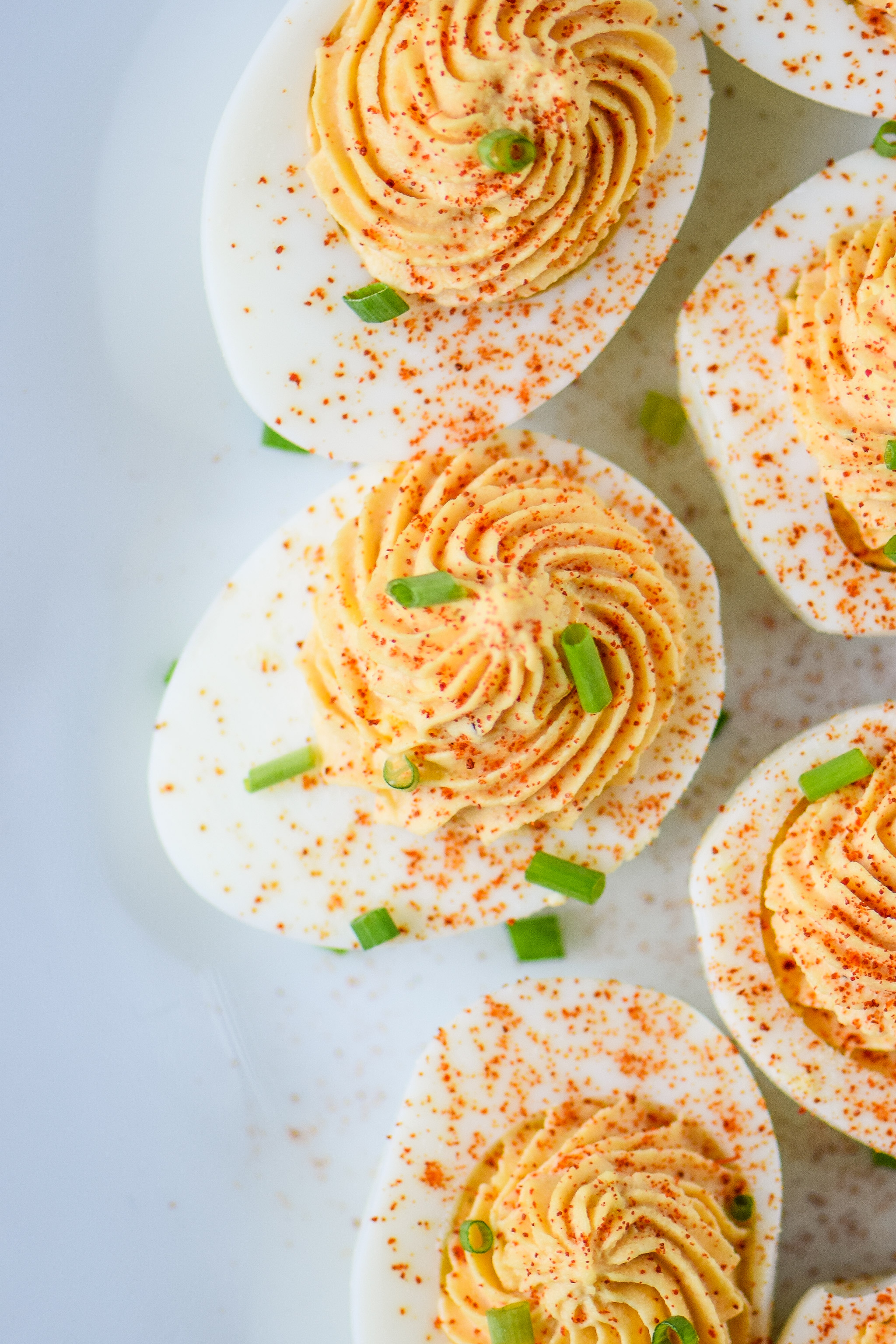 Whole30 Buffalo Deviled Eggs on a white plate pictured from the top.