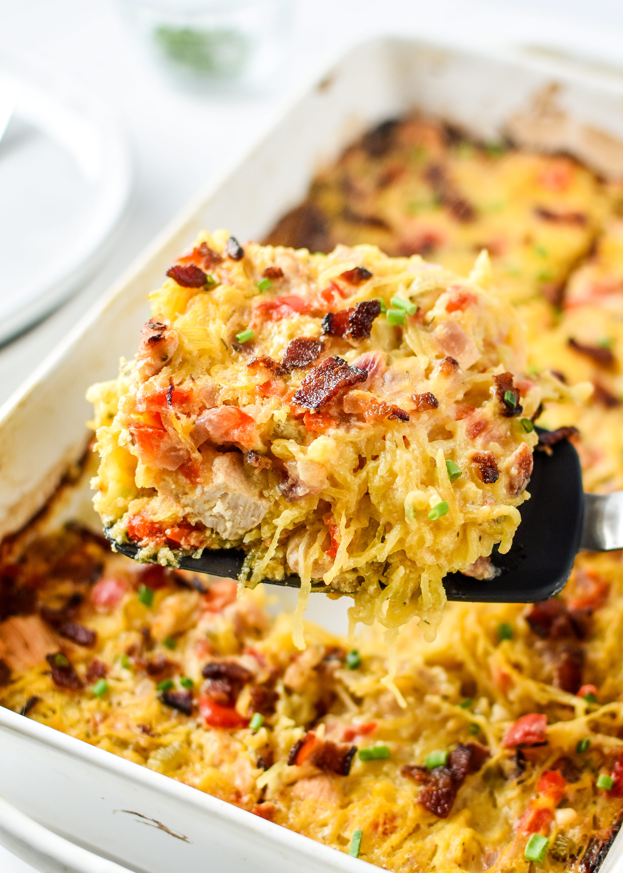 Whole30 Chicken Bacon Ranch casserole being served from a casserole dish.