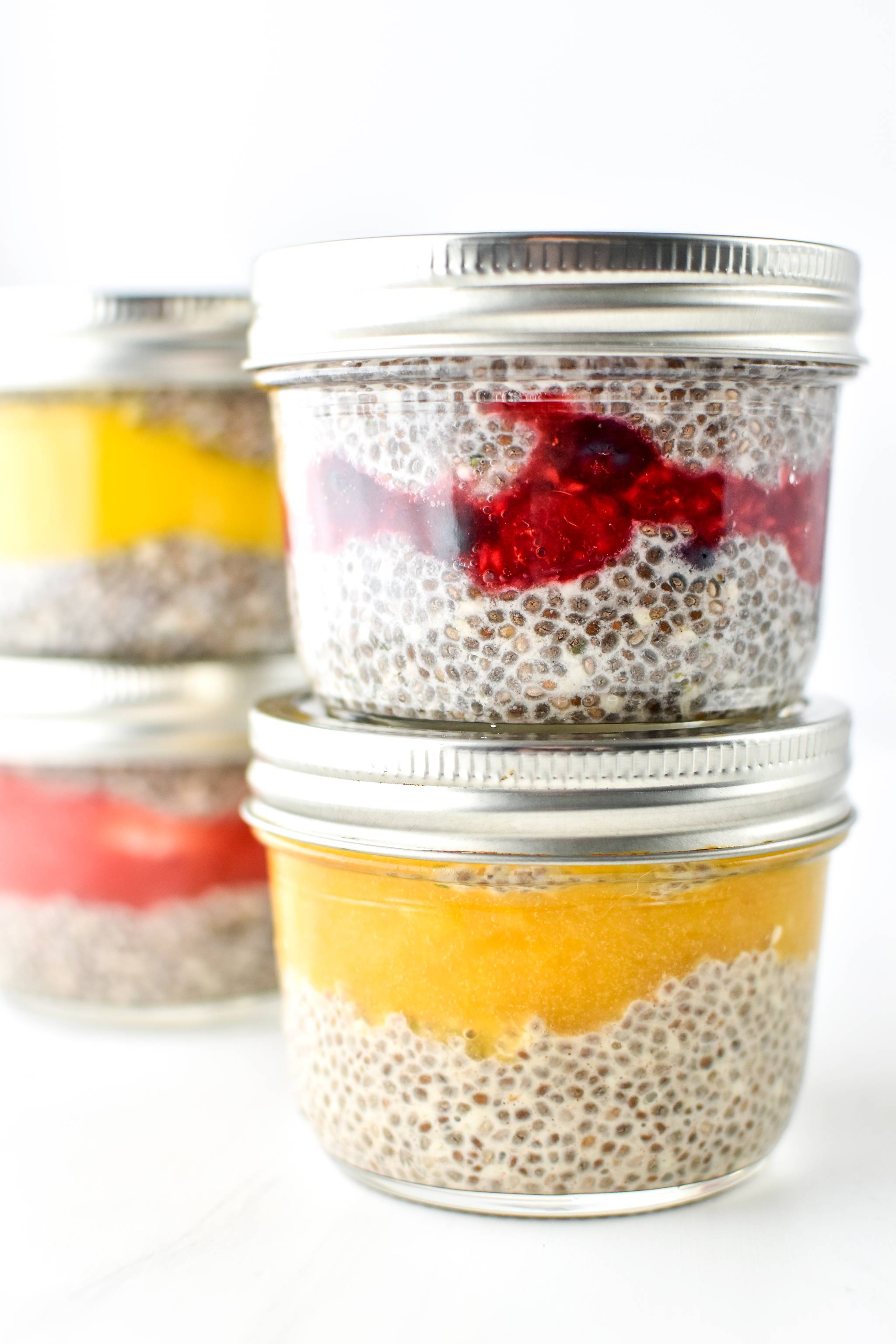 Chia pudding breakfast parfaits of different flavors in half pint mason jars.