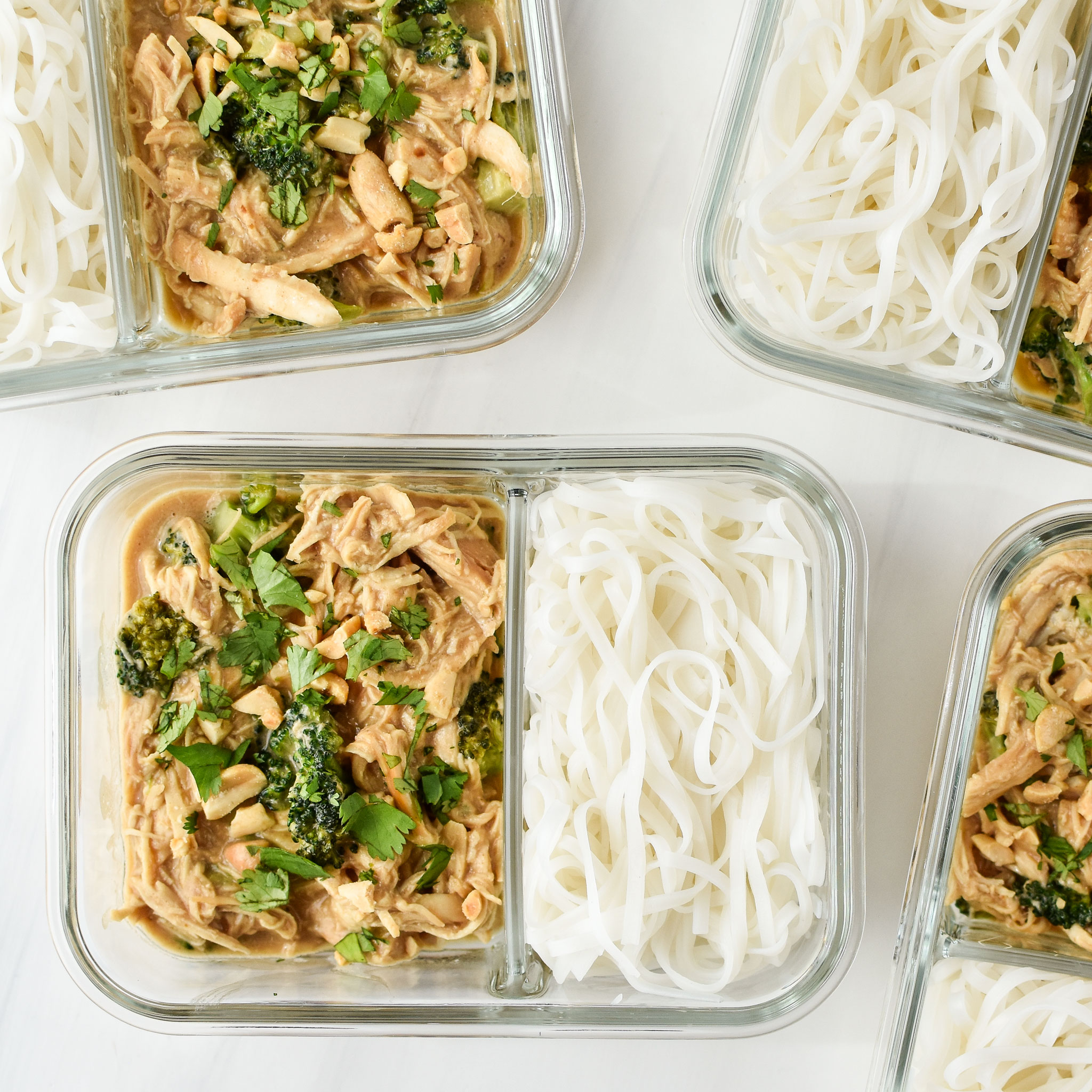 slow cooker peanut chicken noodles meal prep pictured from above in 2 compartment glass meal prep containers