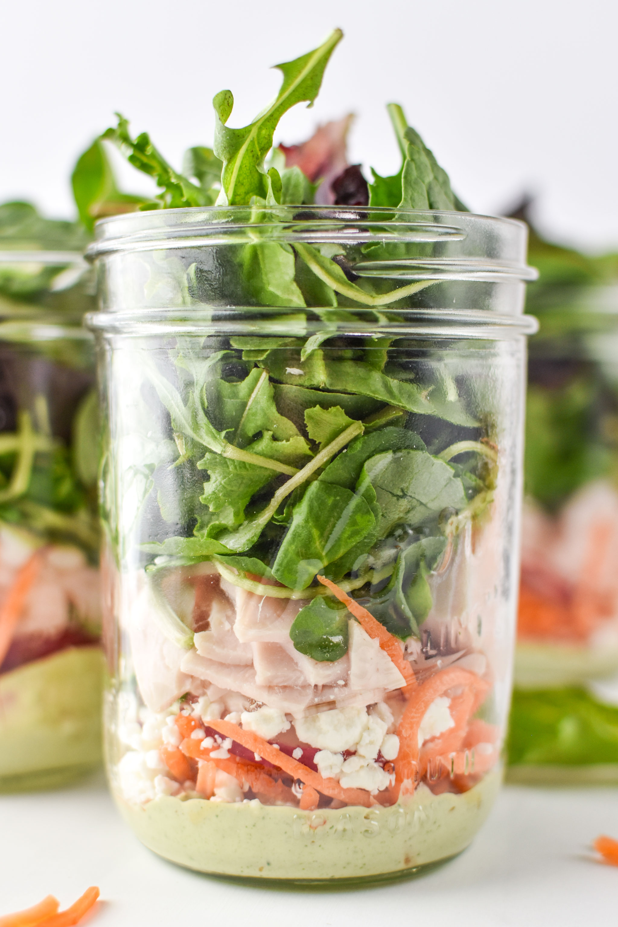 Cilantro lime tahini dressing at the bottom of these mason jar salads