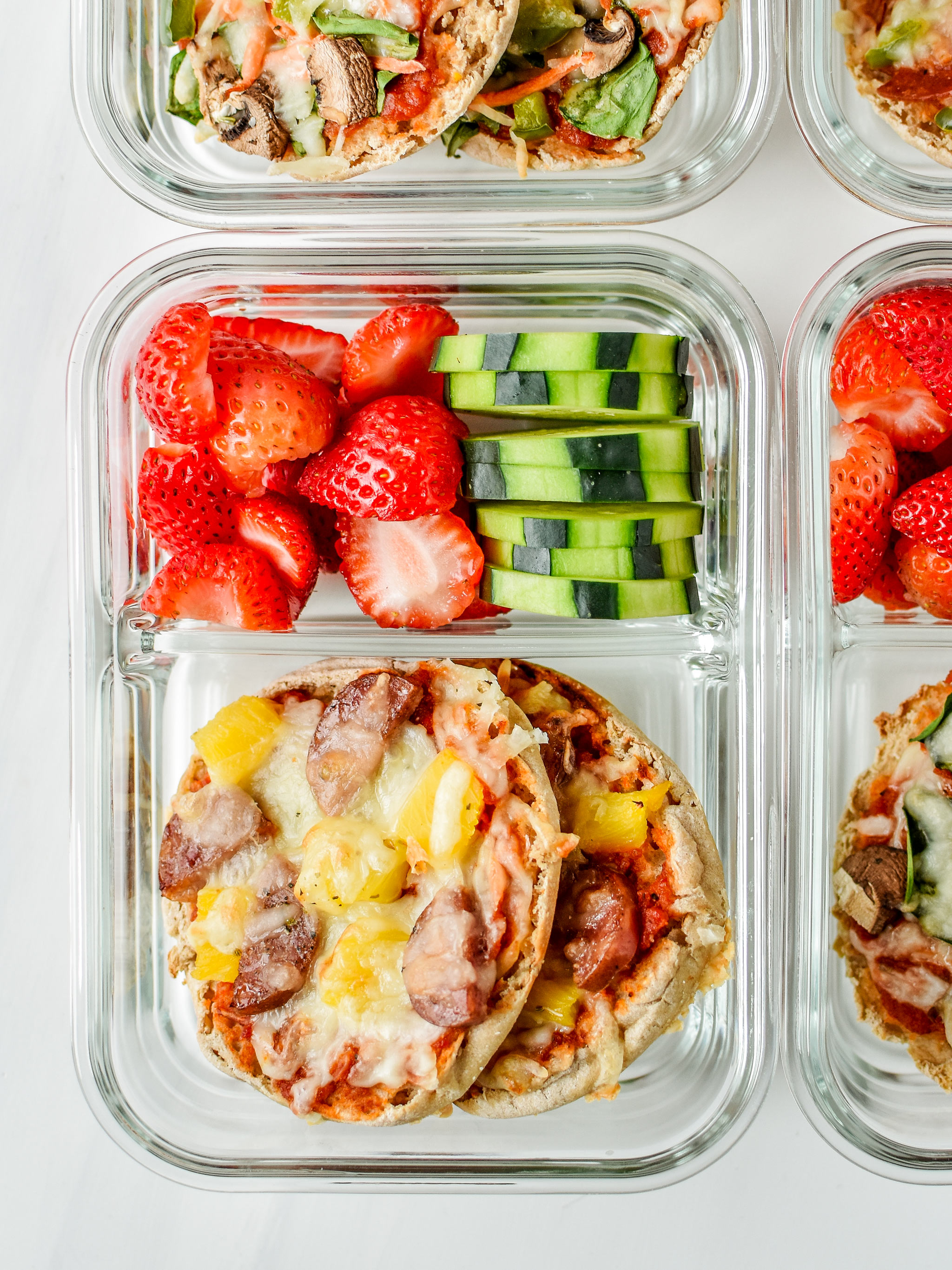 English muffin mini pizzas meal prep - meaty pineapple pictured with fresh cut cucumbers and strawberries