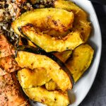 air fryer acorn squash on a plate with rice and chicken