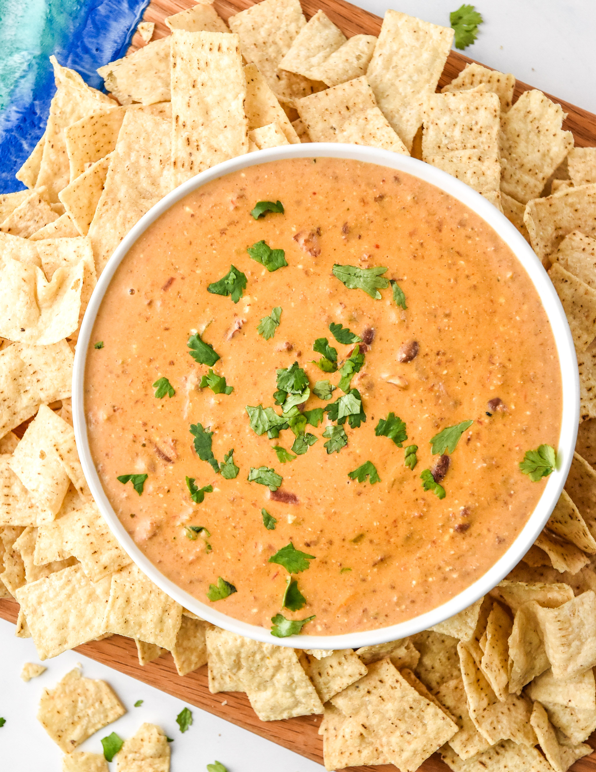 chili cheese dip with chips and cilantro on top
