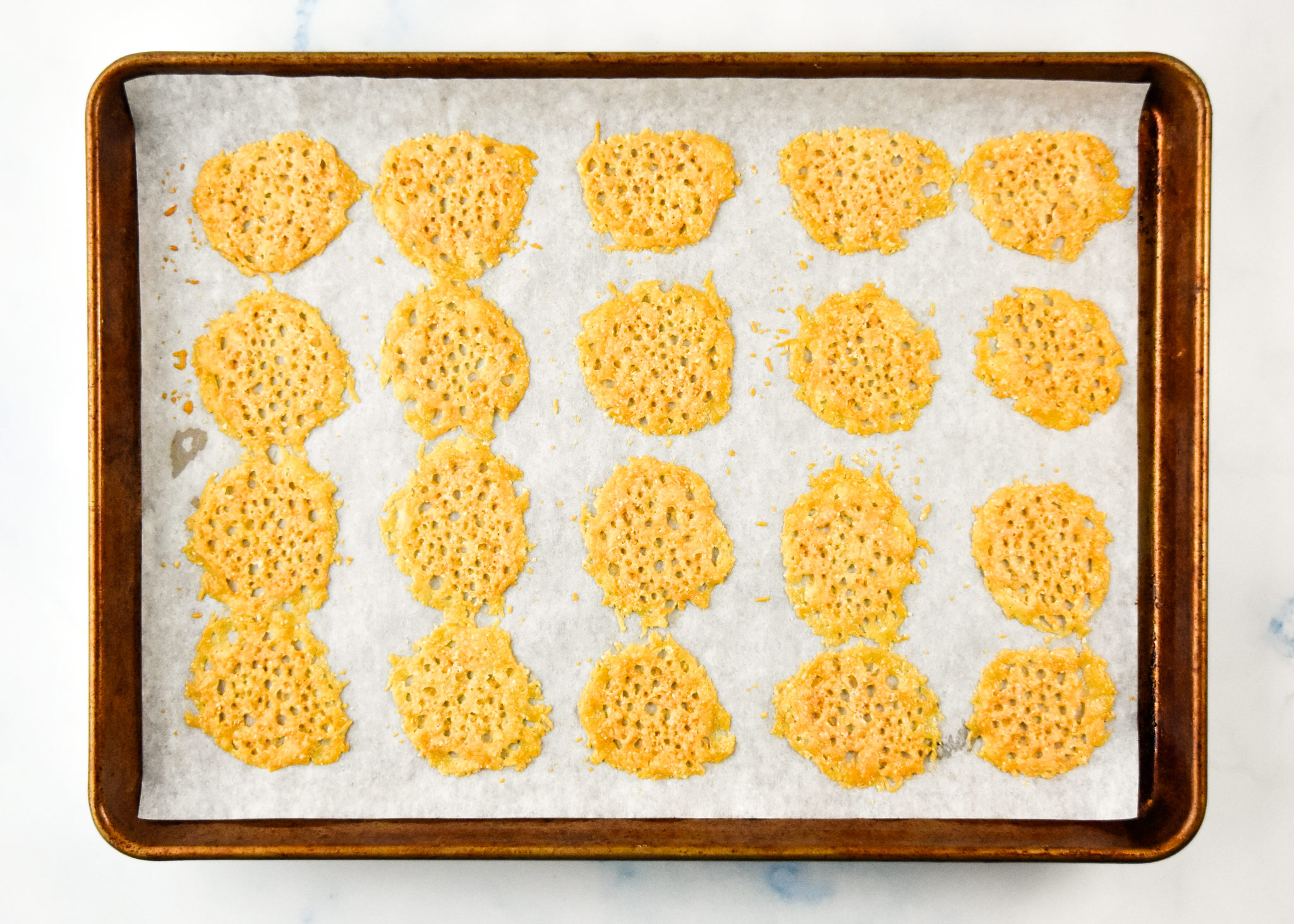 baked parmesan crisps on a baking sheet fresh from the oven