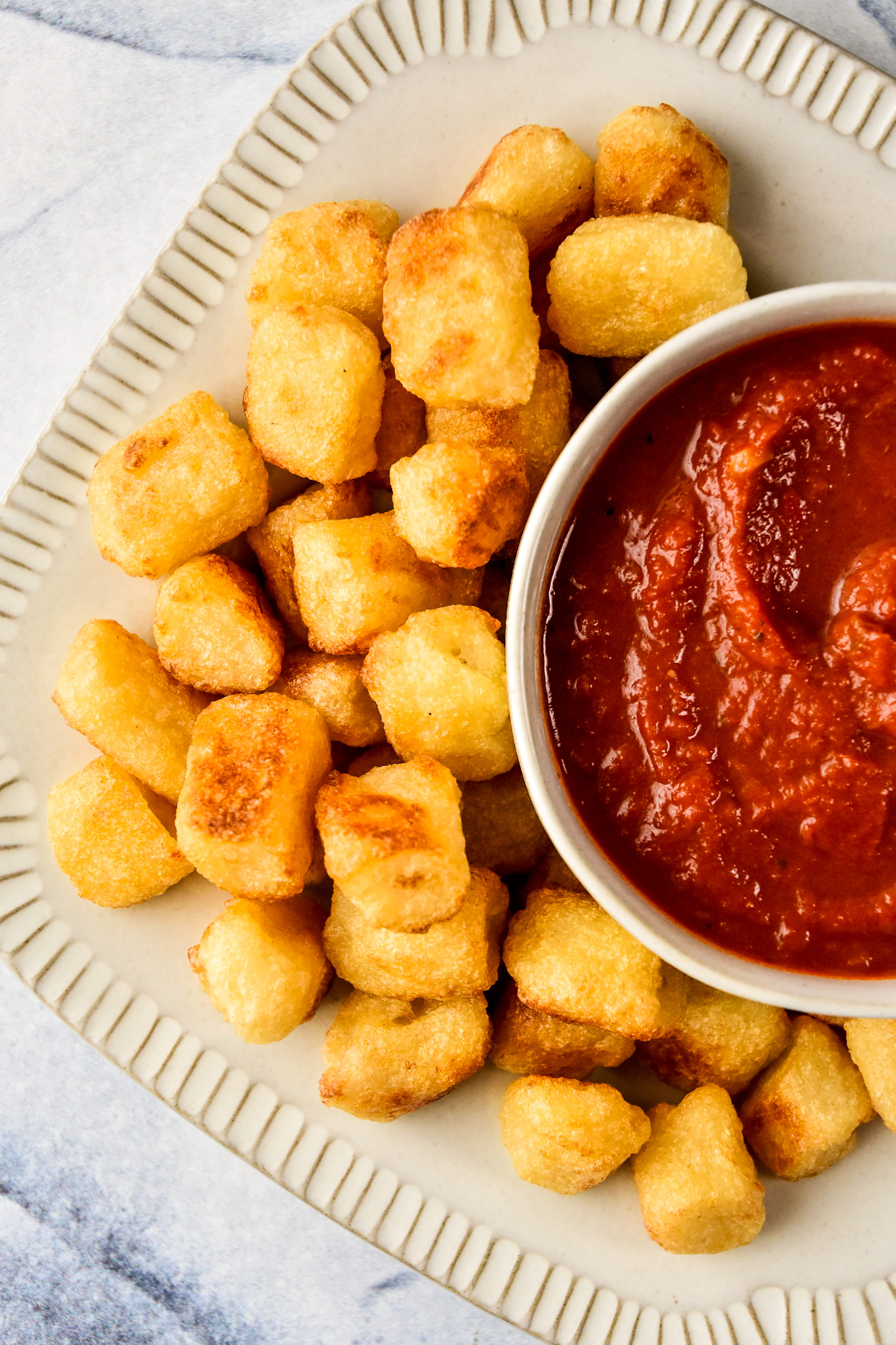 cauliflower gnocchi cooked in an air fryer plated and served with marinara sauce