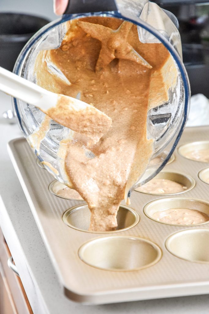 pouring batter from the blender into the muffin pan