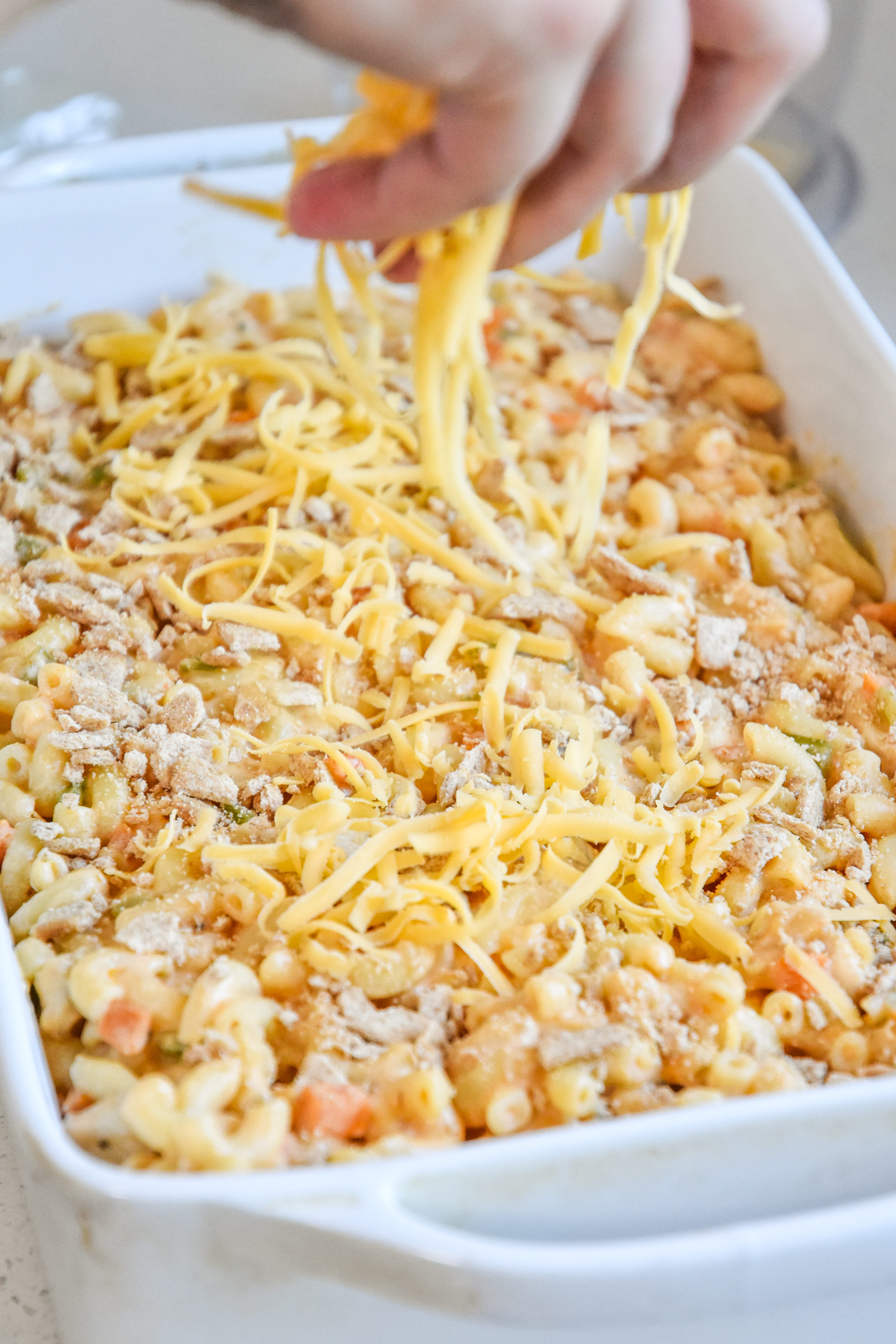 sprinkling cheese on top of the casserole