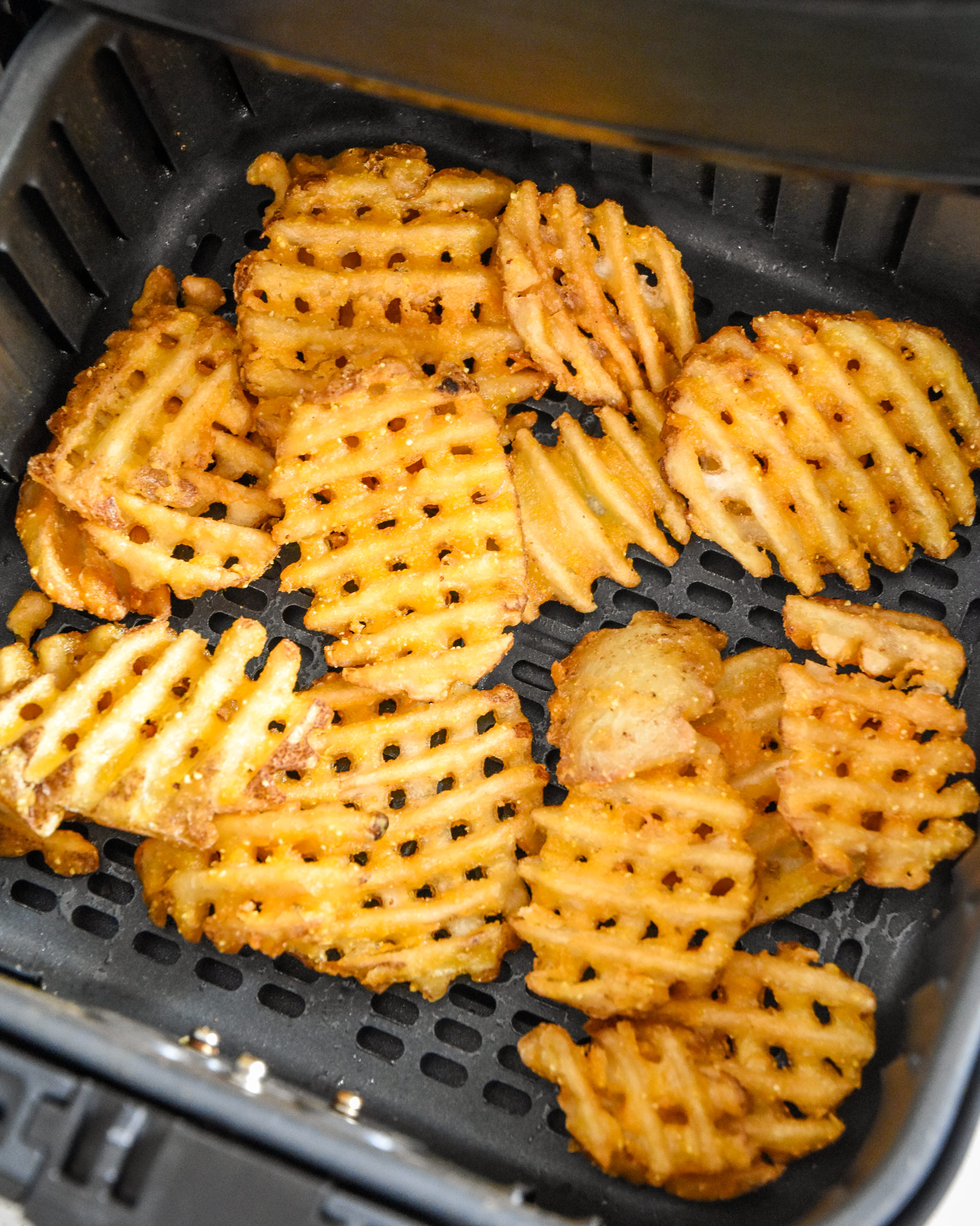 waffle fries in an air fryer basket