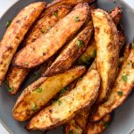 air fryer jojo potatoes wedges on a plate with ketchup on the side.