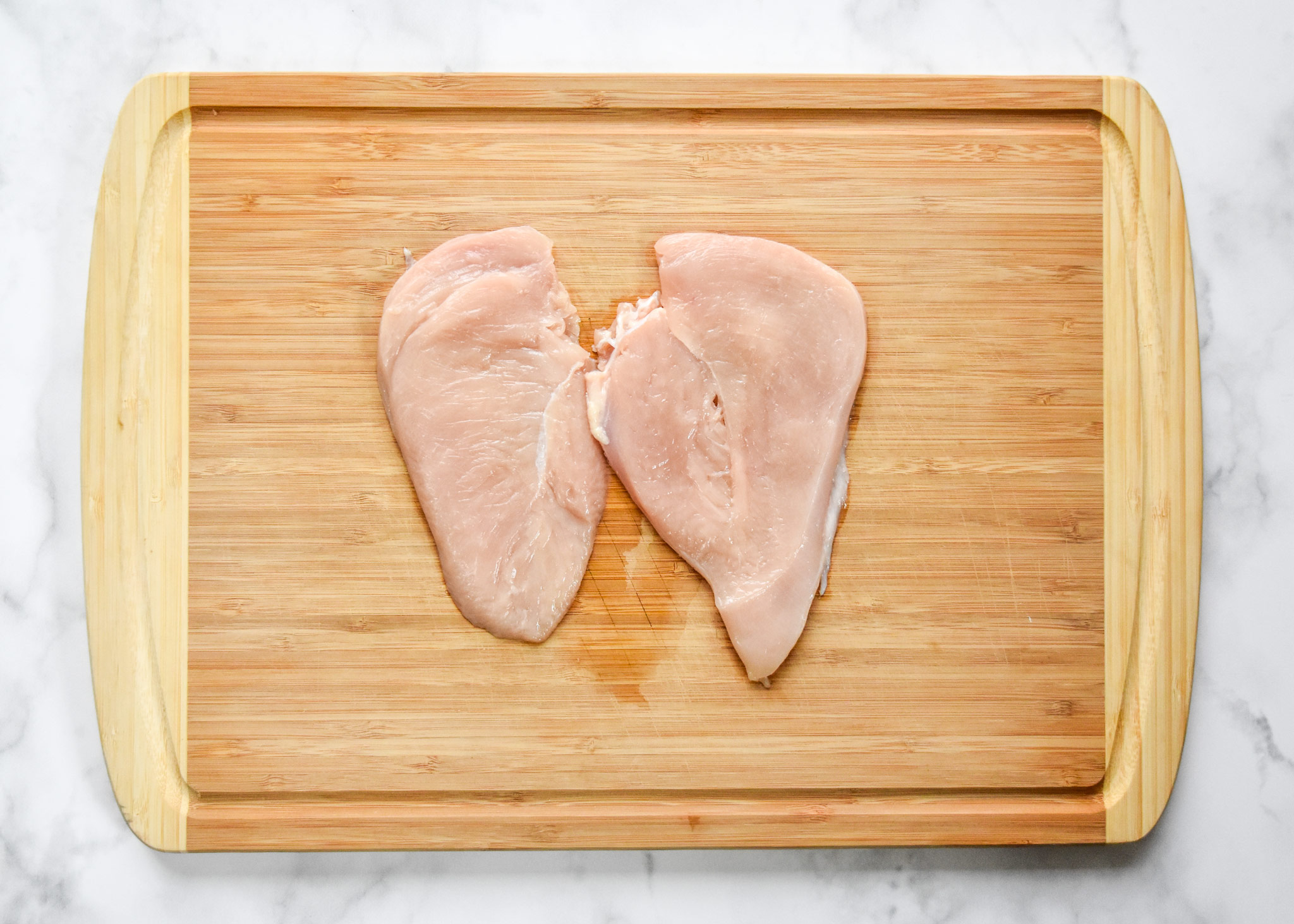 tenderized chicken breast on a cutting board.