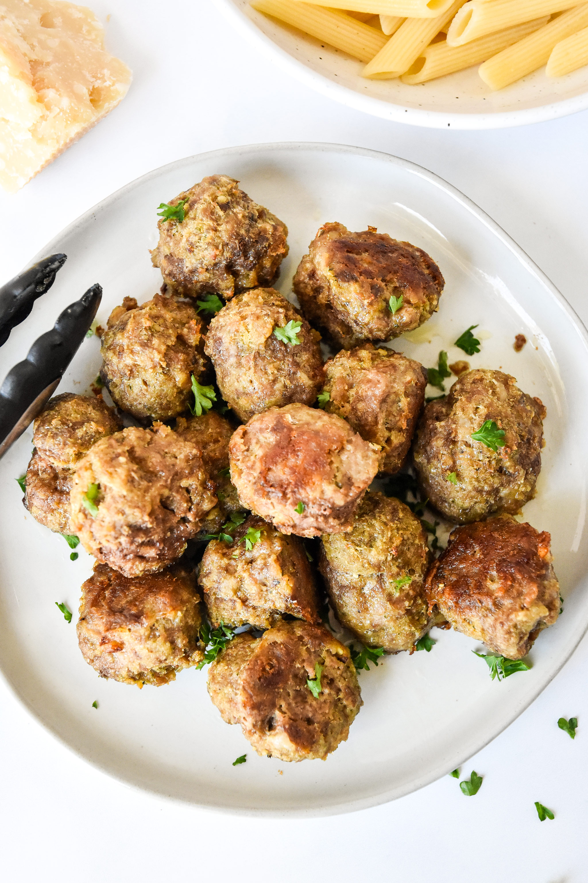 fresh cooked easy freezer friendly meatballs on a plate with parsley sprinkled on top.