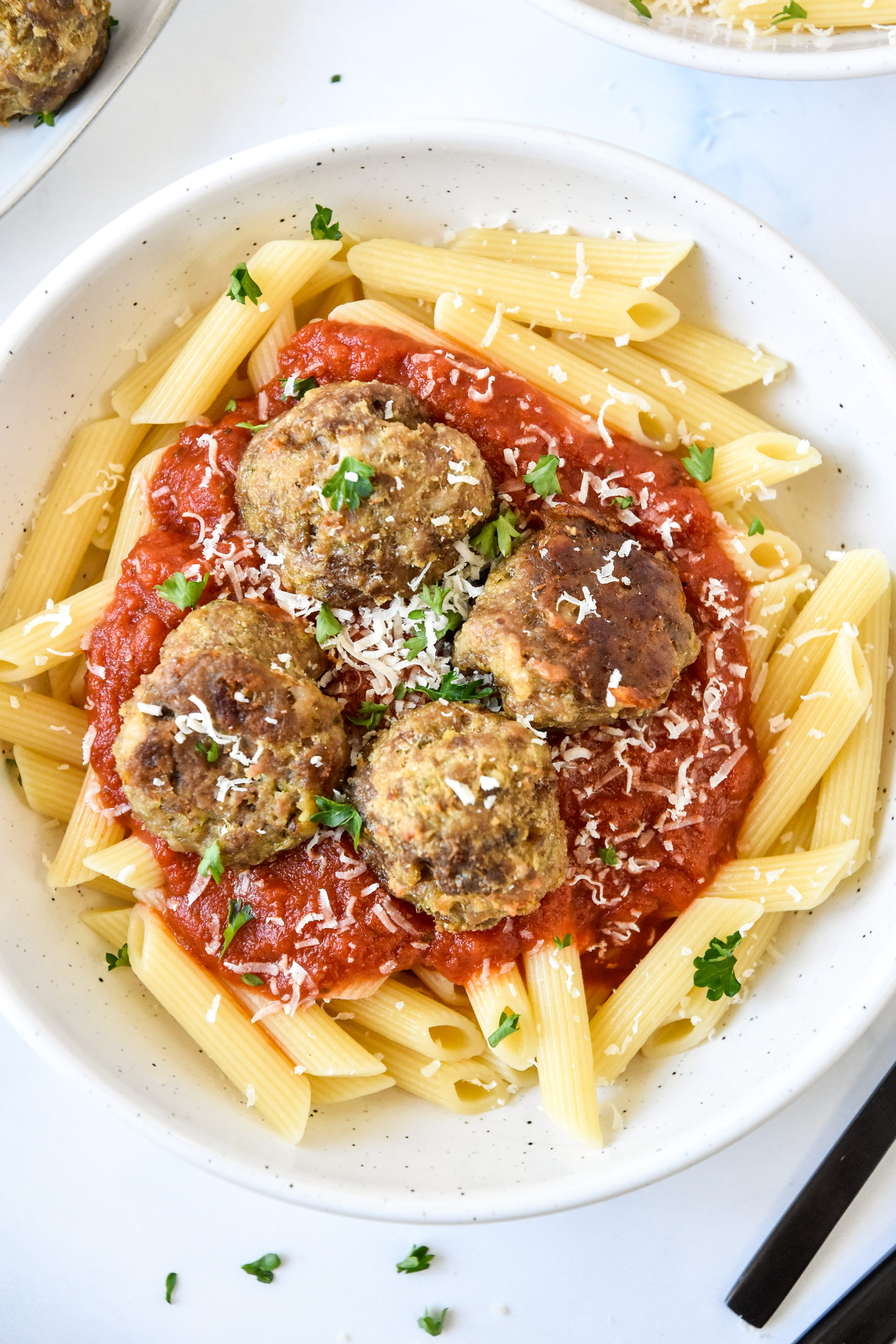 serving meatballs with pasta and red sauce close up.