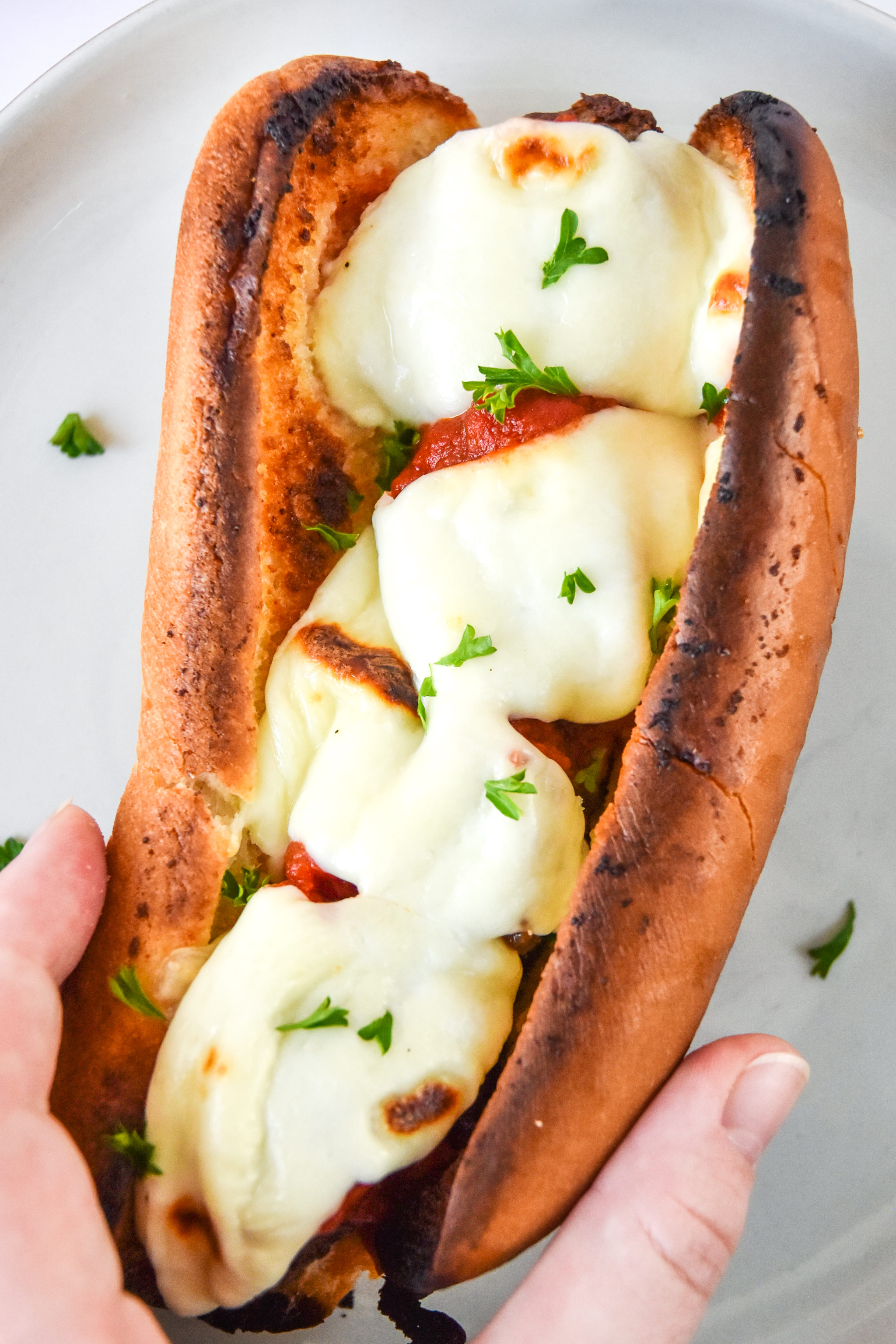 meatball sub sandwich with fresh mozzarella in hand.