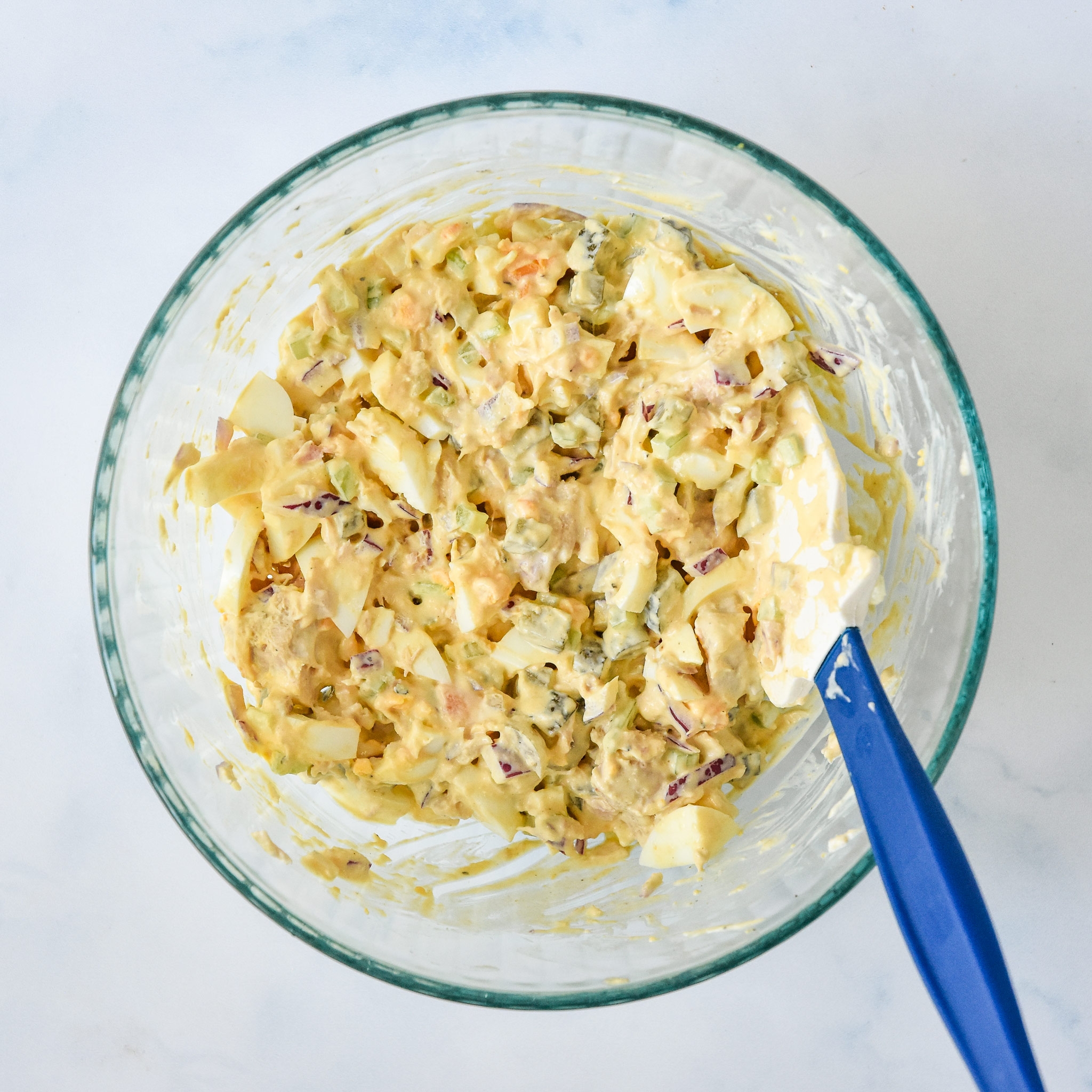 mixed up tuna egg salad in a large glass bowl.