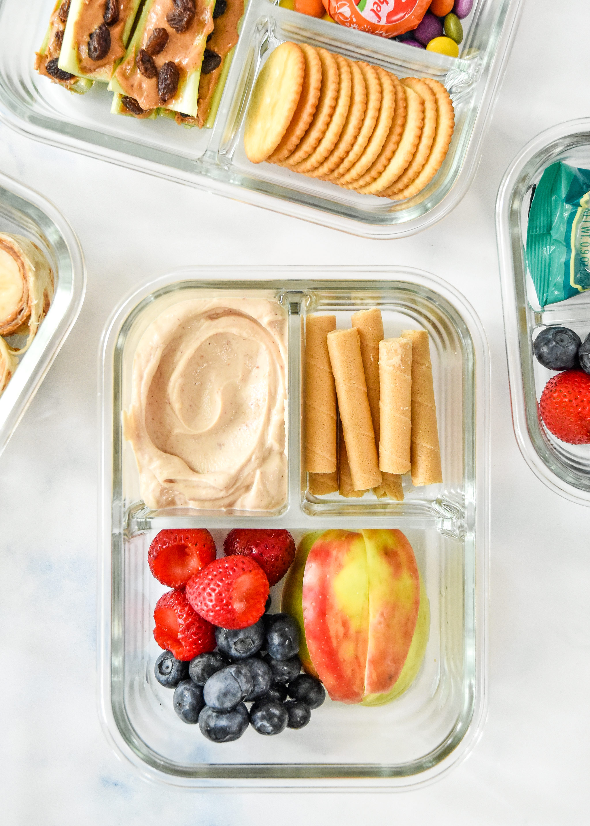 peanut butter yogurt dip with fruit and wafers in a glass meal prep container.