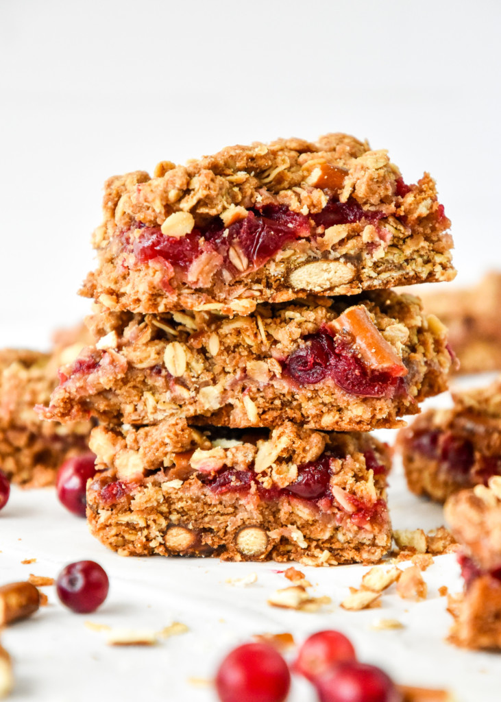 cranberry pretzel oat bars cut and stacked on a table.