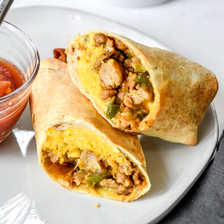 make ahead freezer friendly breakfast burrito cut in half on a plate.