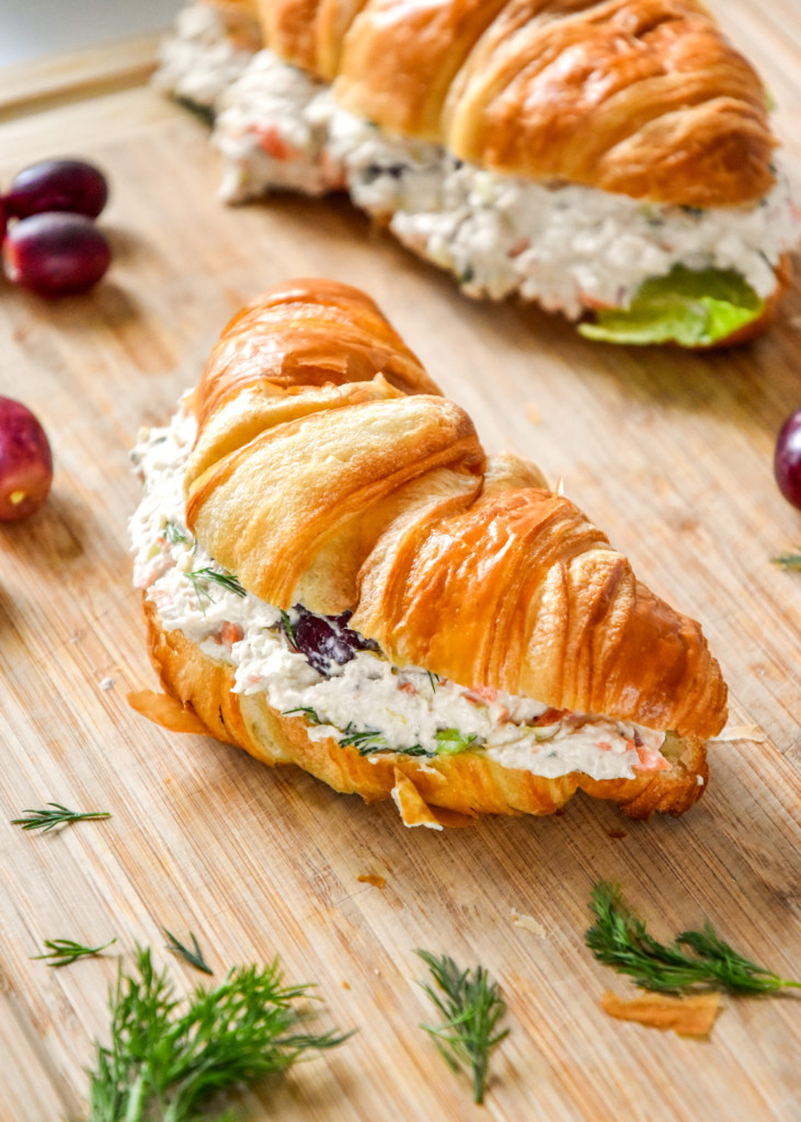 easy chicken salad with grapes on a croissant on a cutting board.