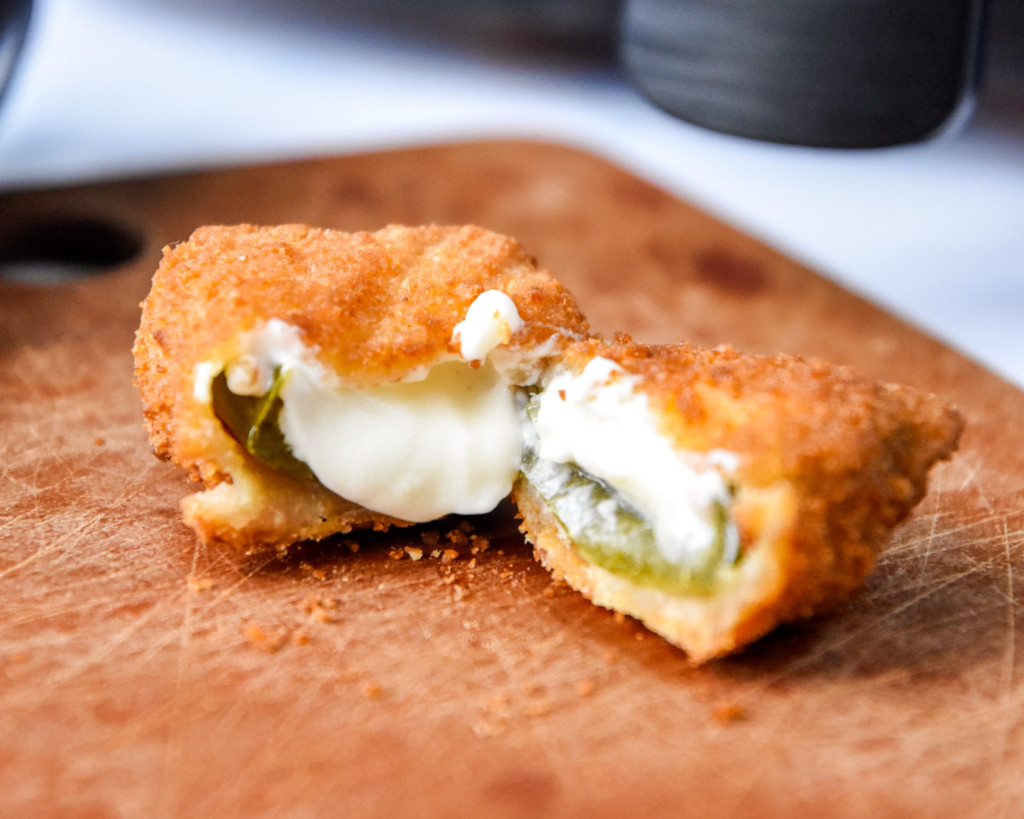 cooked and cut open jalapeno popper appetizer made in the air fryer.