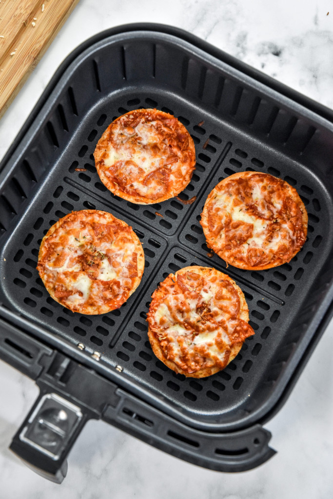 air fryer homemade pizza bagel bites after cooking in the air fryer basket.