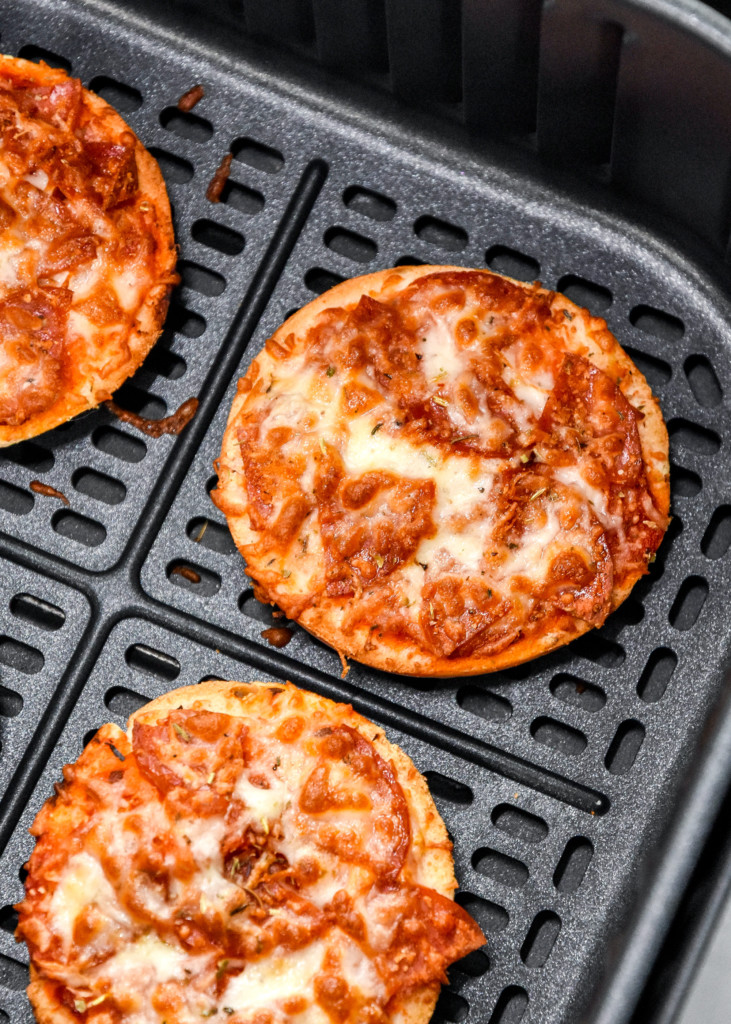 close up of cooked air fryer homemade pizza bagel bites in the air fryer basket.