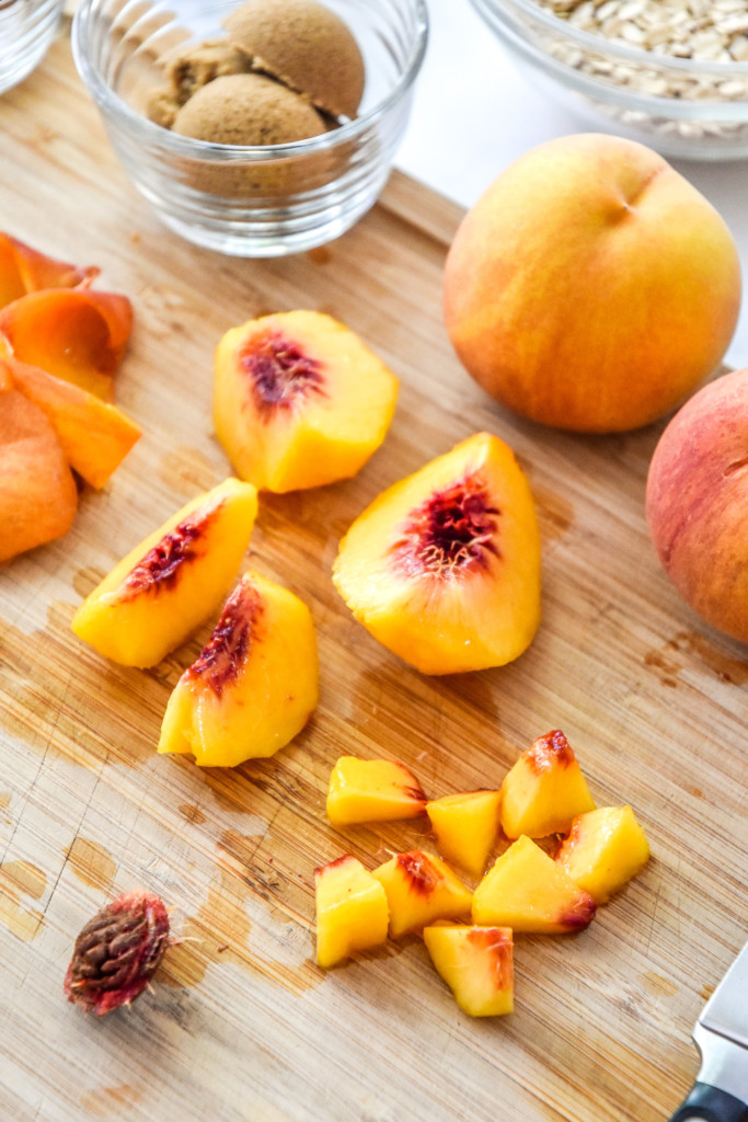 cutting peaches on a wooden cutting board.