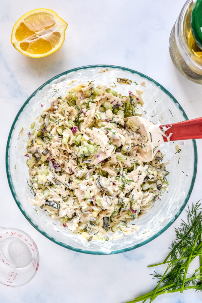 dill pickle chicken salad mixed up in a large glass bowl.