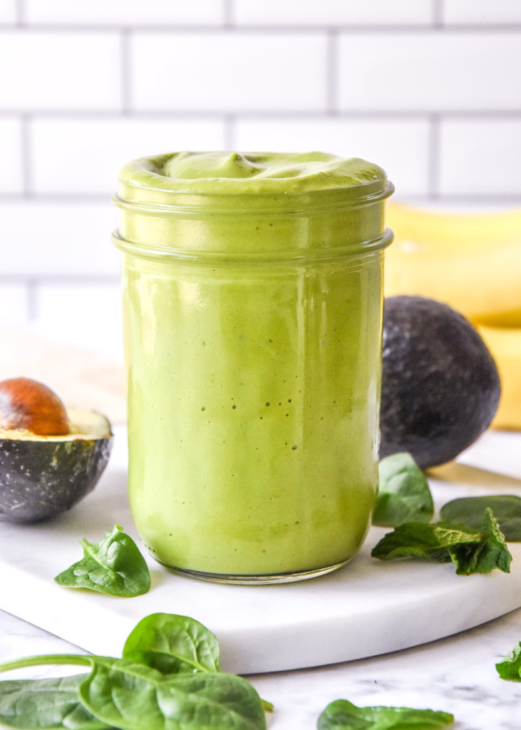 serving the creamy avocado mint green smoothie in a glass jar.