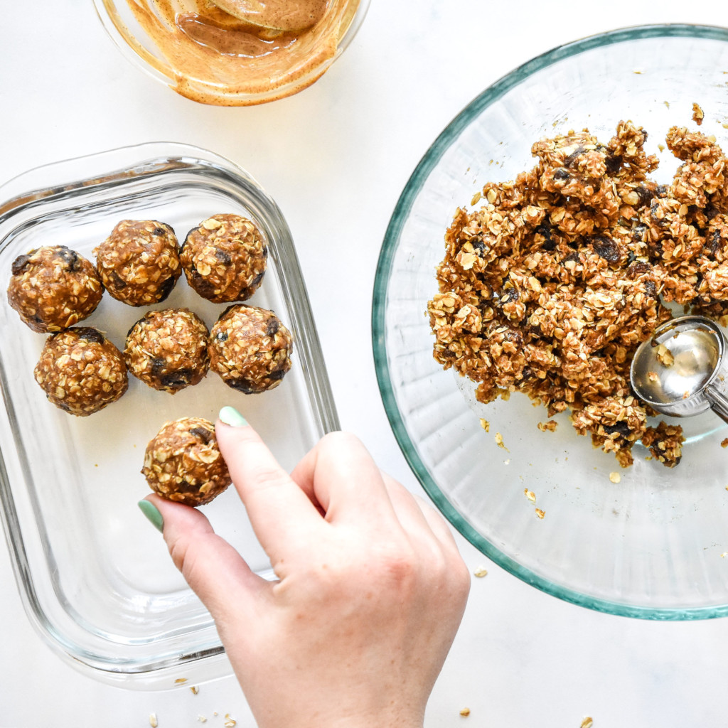 rolling out the no-bake oatmeal raisin cookie balls and placing into a glass container.