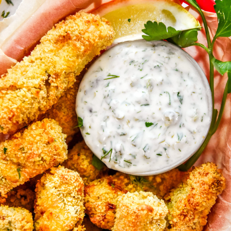 close up of the yogurt tartar sauce in a basket of fish sticks.