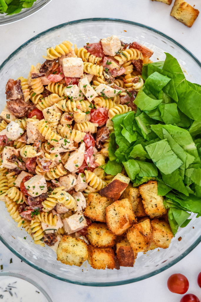 make-ahead chicken club pasta salad in a large bowl with croutons and lettuce.