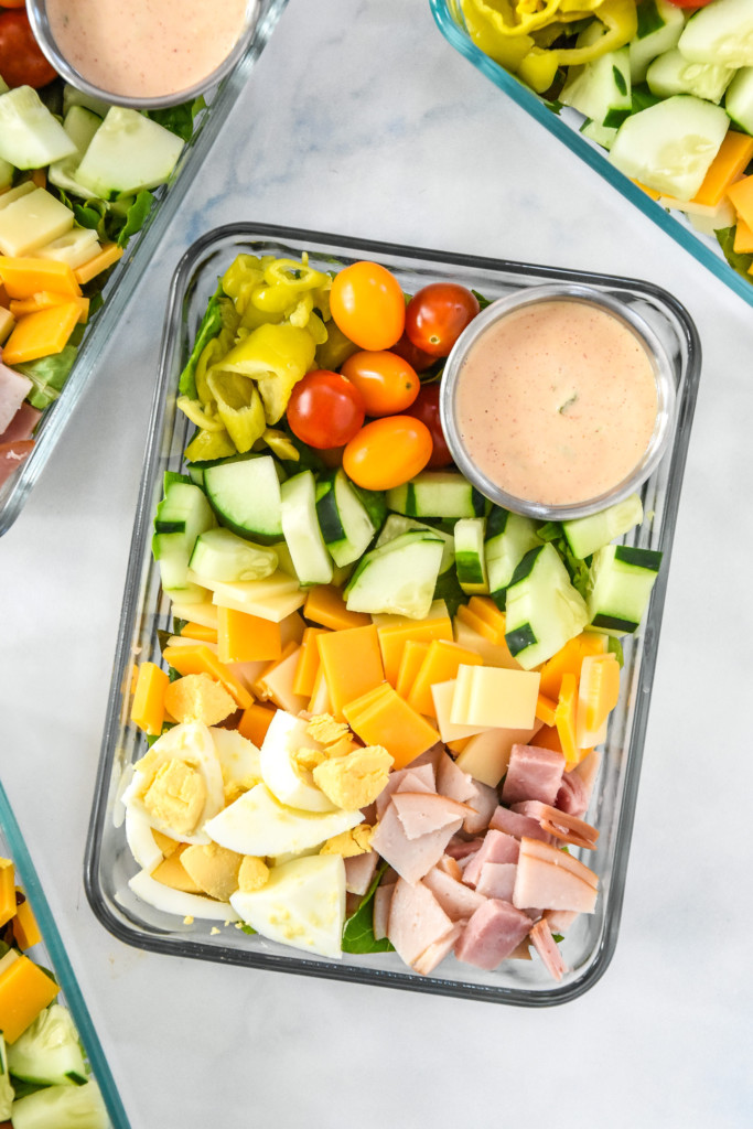 easy chef salad meal prep with dressing cup in a glass meal prep container.