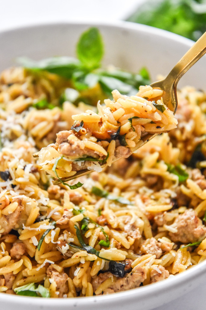 a bite of ground turkey zucchini orzotto on a gold fork.