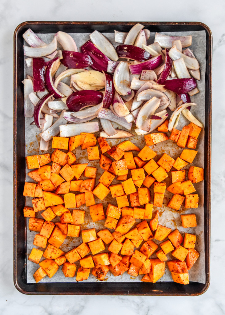 butternut squash and red onions on a sheet pan before baking.