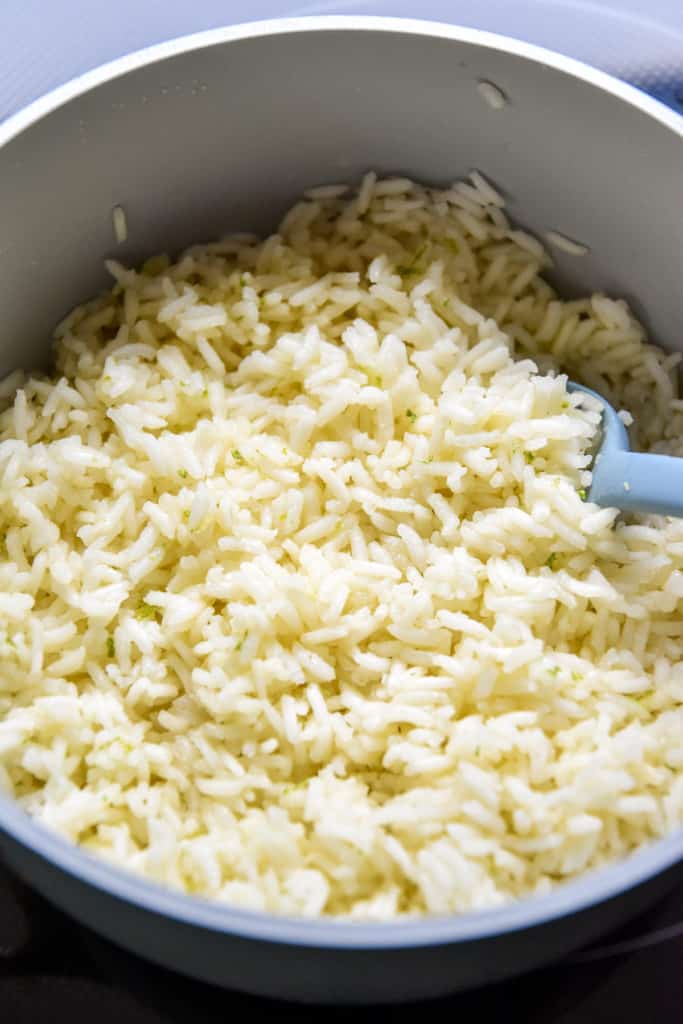 fresh cooked white rice in a pan with a spoon.