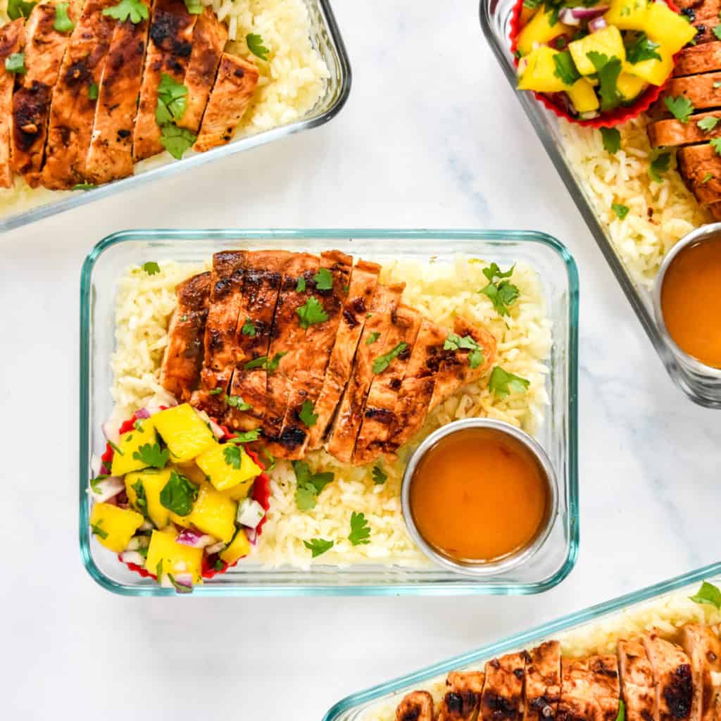 chipotle lime chicken meal prep with mango salad in a glass meal prep bowl.