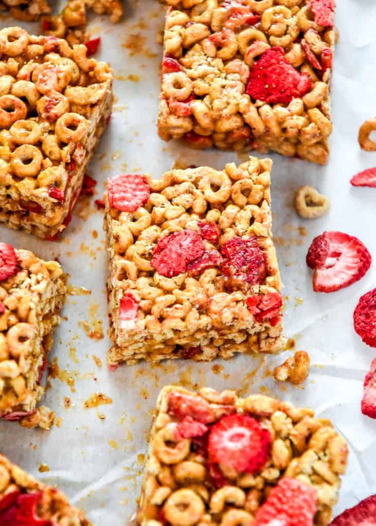 Strawberry Peanut Butter Cheerios Bars cut into squares on parchment paper.