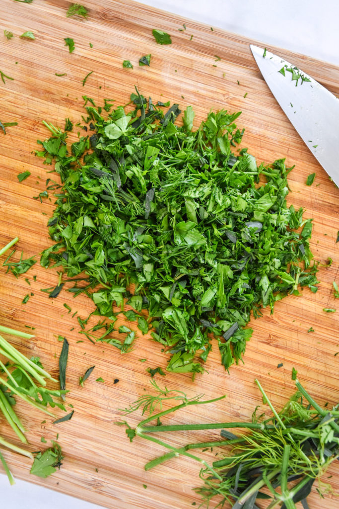 chopped herbs on a cutting board.