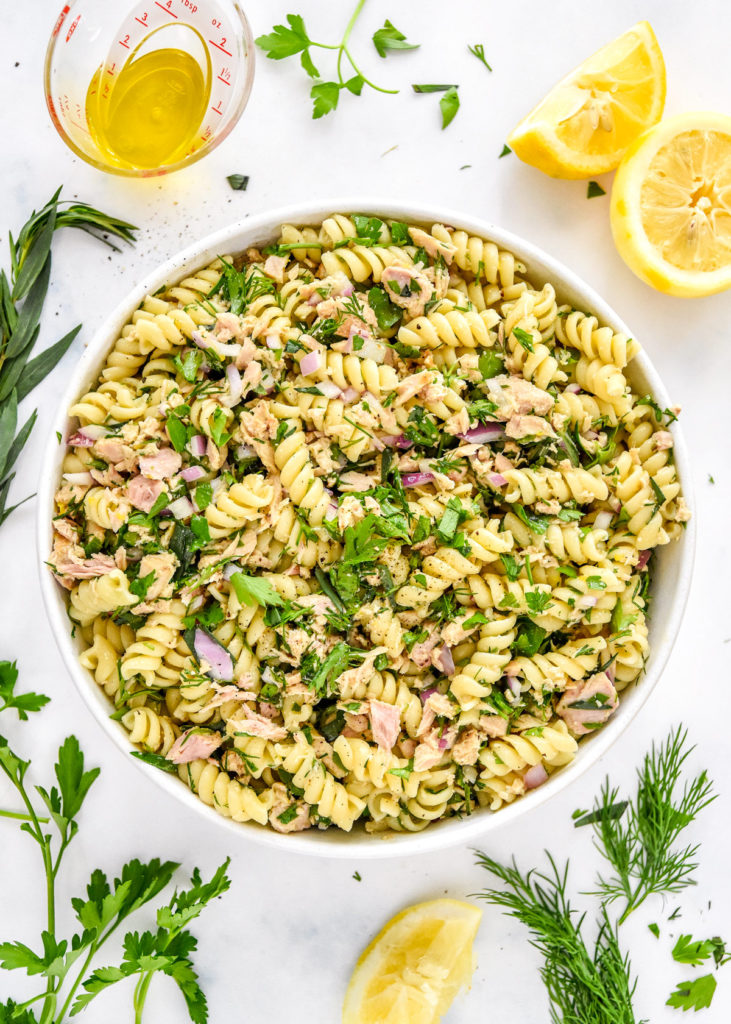 lemon vinaigrette tuna pasta salad with fresh herbs in a serving bowl. 